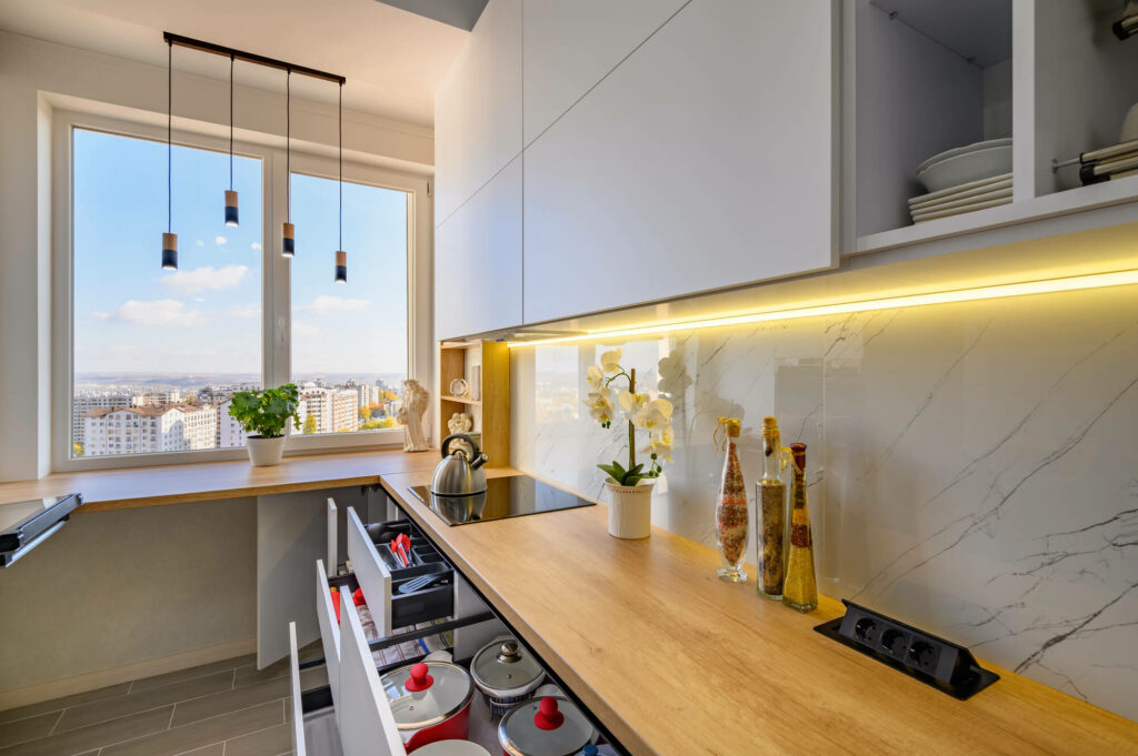 petite cuisine lumineuse avec mobilier blanc laqué et éclairage LED intégré