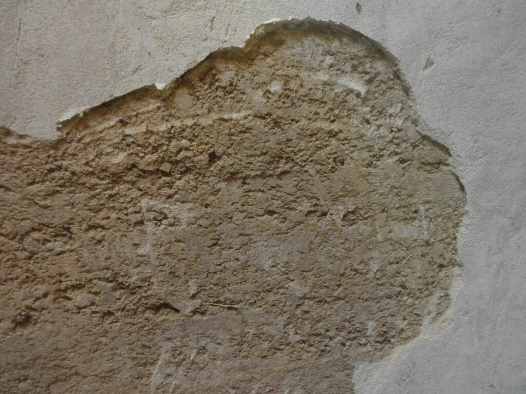 enduit ciment abimé sur mur pisé