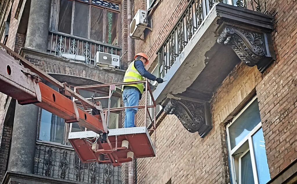 Application d'un produit de protection anticorrosion sur les fers à béton d'un balcon en réparation.