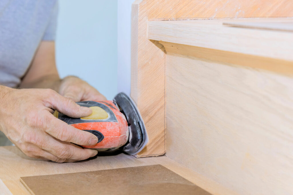 un artisan en train de poncer un escalier