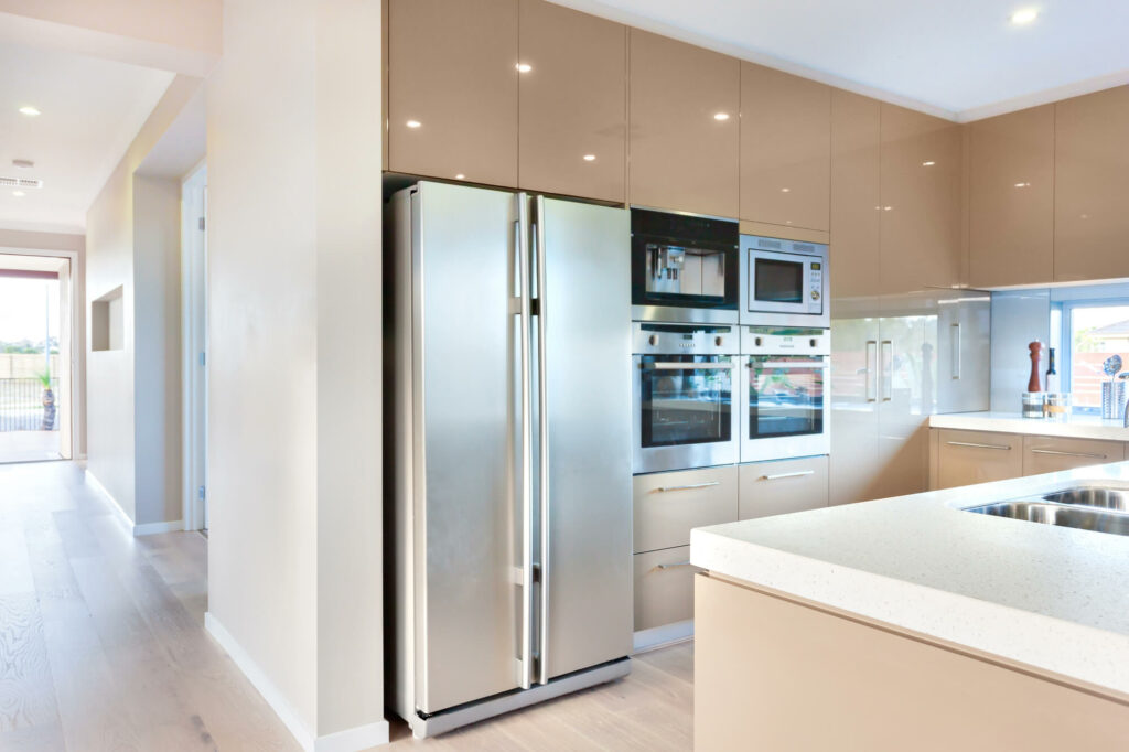 Électroménager en pose libre dépassant de l'alignement des meubles standards de cuisine aménagée.