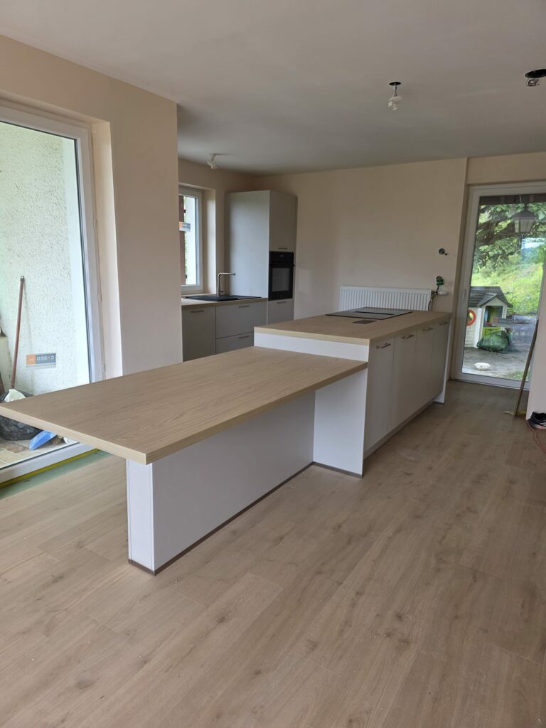 îlot central hybride à deux hauteurs : 90 cm pour la préparation et 75 cm pour les repas en famille