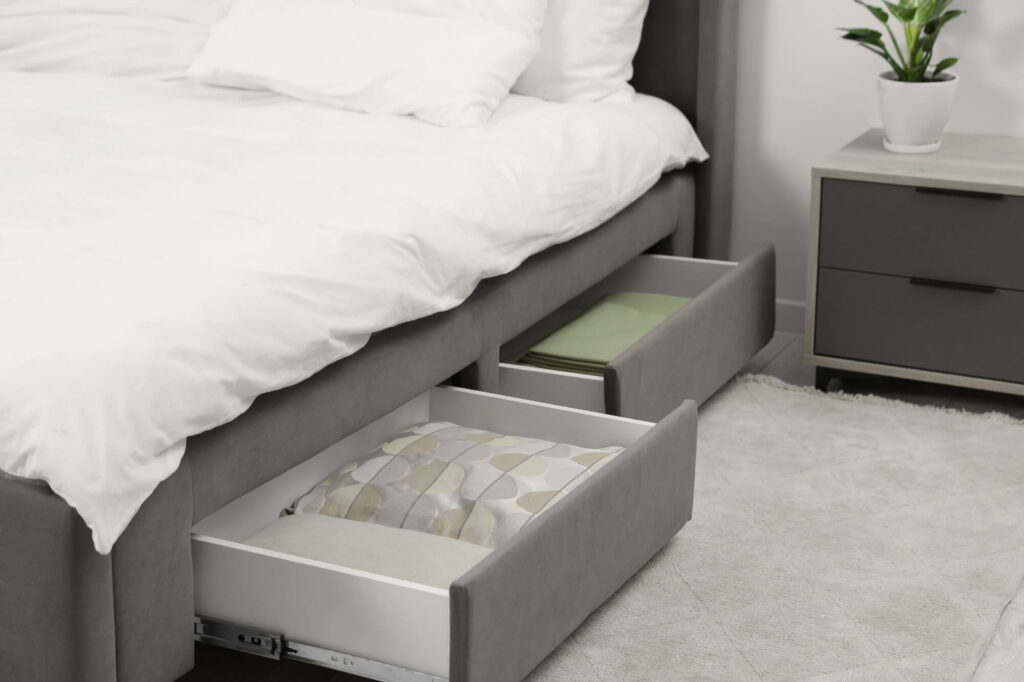 Lit coffre à sommier ouvert sur un espace de rangement pour le linge de saison
