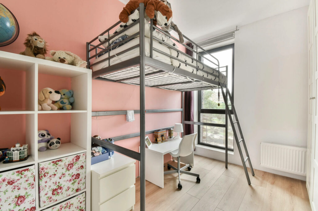 Lit mezzanine installé dans une chambre pour libérer un bureau en dessous