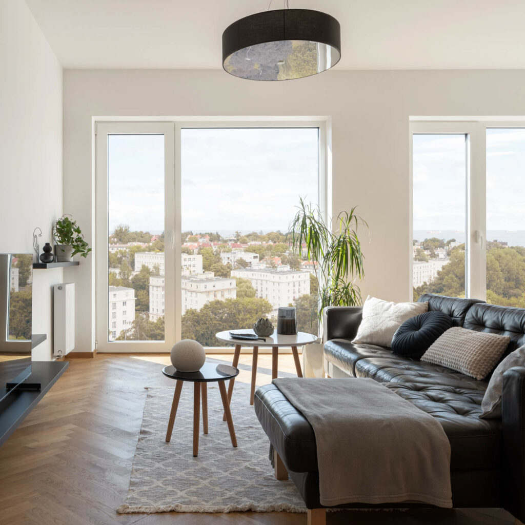 Mobilier complémentaire adapté à un canapé d'angle : table basse ronde et meuble TV suspendu